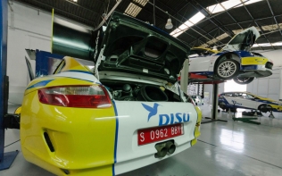 DISA-branded racecars in a garage