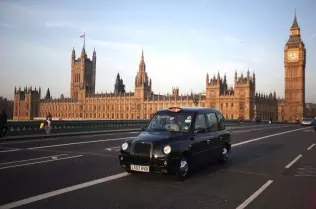 An autogas-powered black cab in front of the Houses of Parliament in London